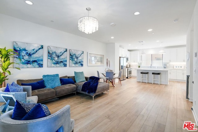 living room featuring light hardwood / wood-style floors and an inviting chandelier