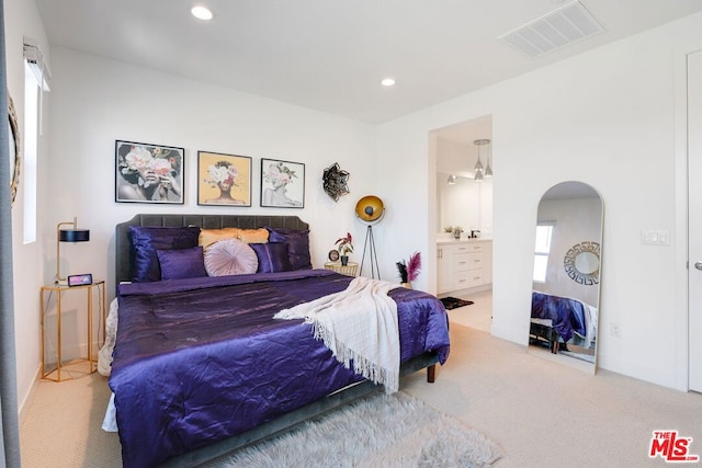 bedroom featuring ensuite bath and carpet floors