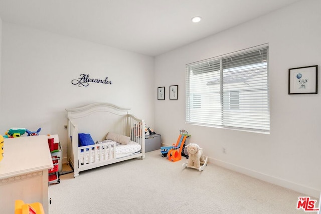 bedroom featuring a crib and carpet floors