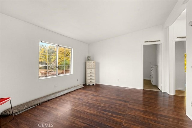 empty room featuring dark hardwood / wood-style floors and vaulted ceiling