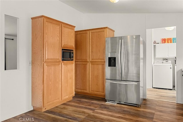 kitchen featuring appliances with stainless steel finishes, dark hardwood / wood-style flooring, washer / clothes dryer, and vaulted ceiling