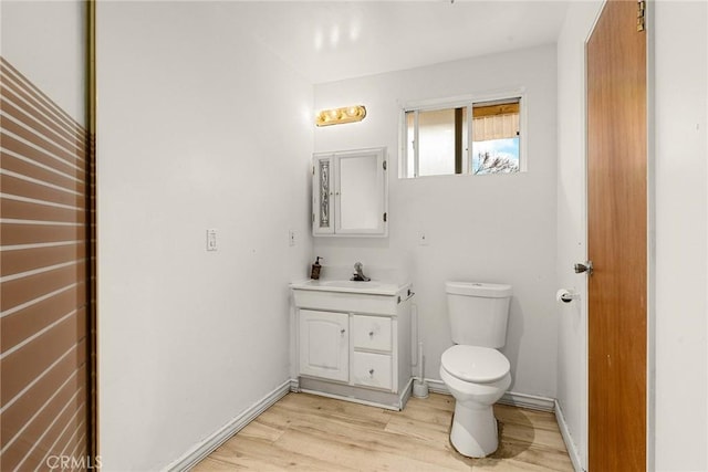 bathroom with hardwood / wood-style floors, vanity, and toilet