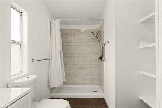 bathroom with walk in shower, a textured ceiling, toilet, vanity, and hardwood / wood-style flooring