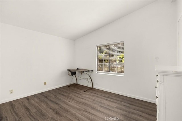 unfurnished room with dark wood-type flooring and vaulted ceiling