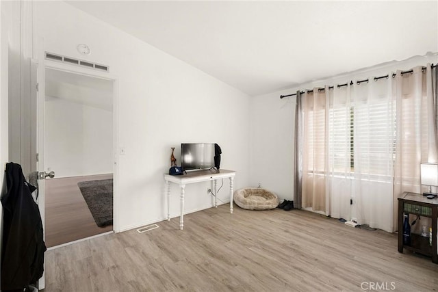 interior space featuring light hardwood / wood-style floors and lofted ceiling