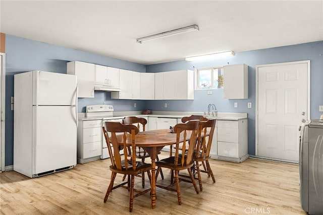 kitchen with white cabinetry, light wood-type flooring, white appliances, and washer / dryer