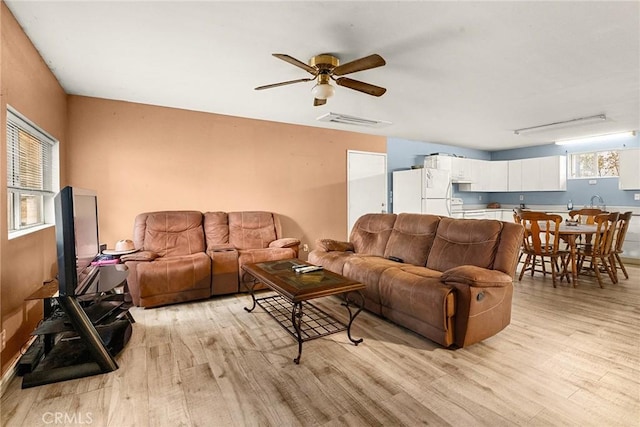 living room with ceiling fan and light hardwood / wood-style flooring