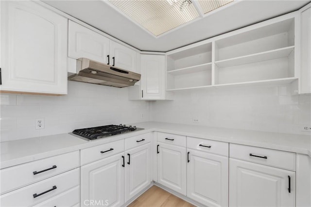 kitchen featuring white cabinets, stainless steel gas stovetop, light hardwood / wood-style floors, and tasteful backsplash