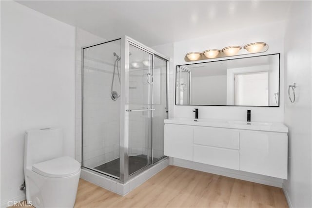 bathroom with toilet, vanity, an enclosed shower, and hardwood / wood-style flooring