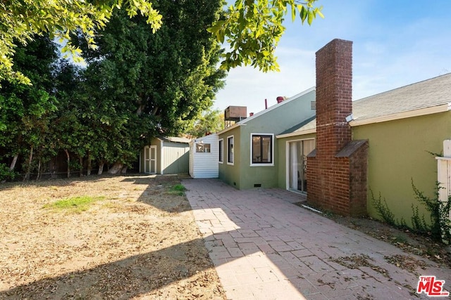 exterior space with a storage unit and a patio area