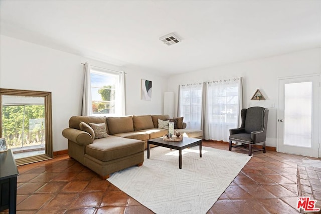 living room featuring dark tile patterned floors and a healthy amount of sunlight