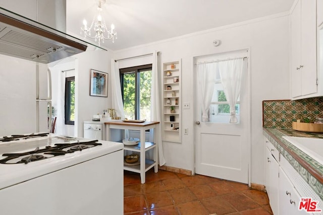 kitchen with white appliances, backsplash, white cabinetry, and a notable chandelier