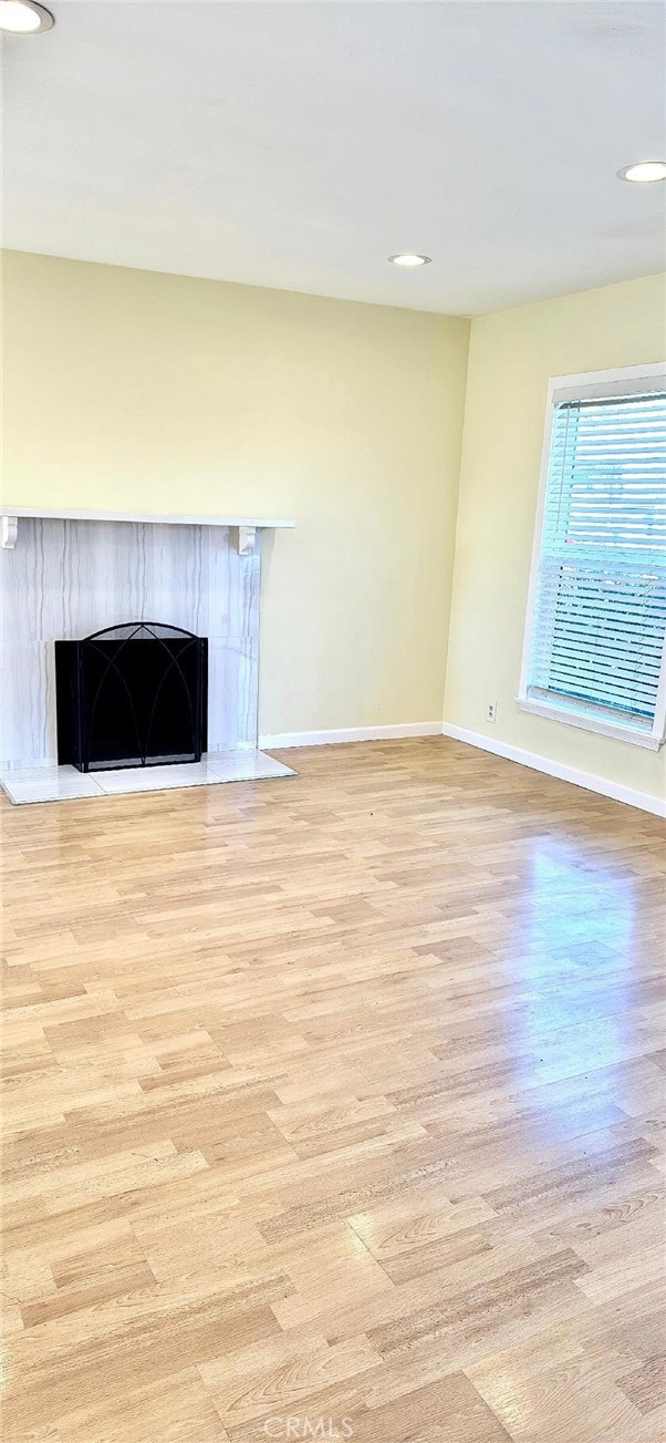 unfurnished living room with a fireplace and light hardwood / wood-style floors