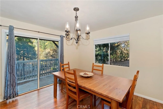 dining room with hardwood / wood-style flooring and a chandelier