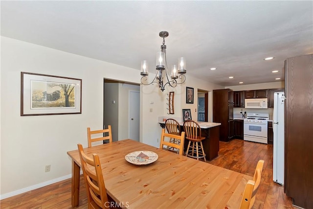 dining area featuring dark hardwood / wood-style floors and an inviting chandelier