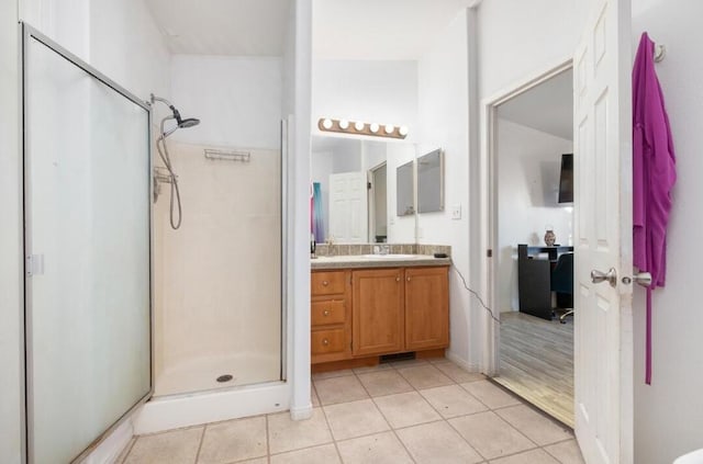 bathroom featuring tile patterned flooring, walk in shower, and vanity