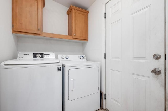 washroom with cabinets and washer and dryer