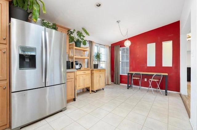 kitchen featuring hanging light fixtures, light brown cabinetry, and stainless steel fridge