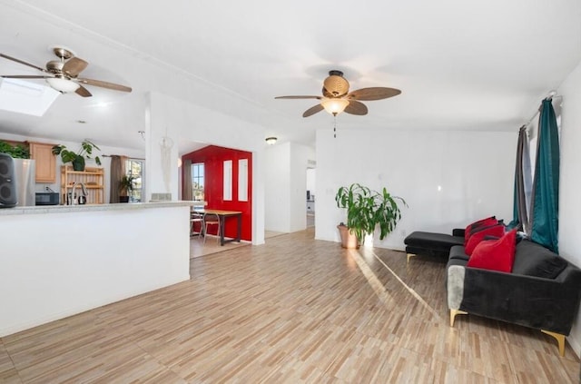 living room with ceiling fan and light hardwood / wood-style floors