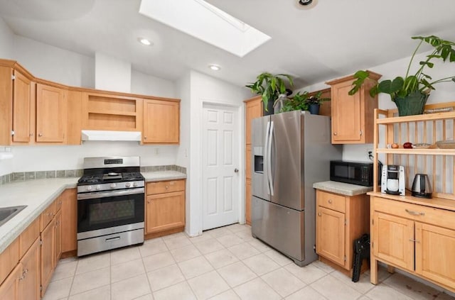 kitchen with light tile patterned floors, appliances with stainless steel finishes, and a skylight