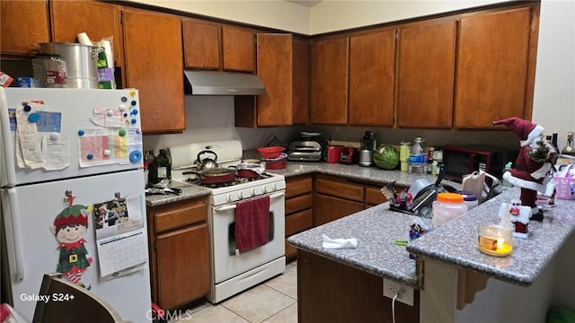 kitchen featuring light tile patterned floors and white appliances