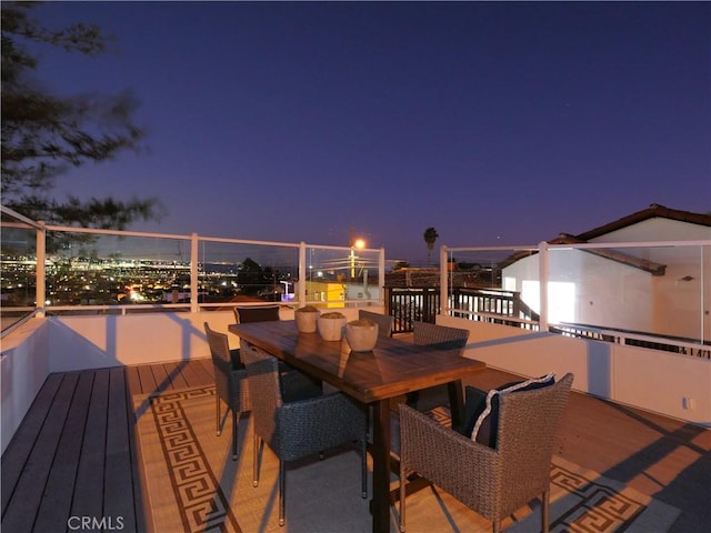 deck at twilight featuring outdoor dining area