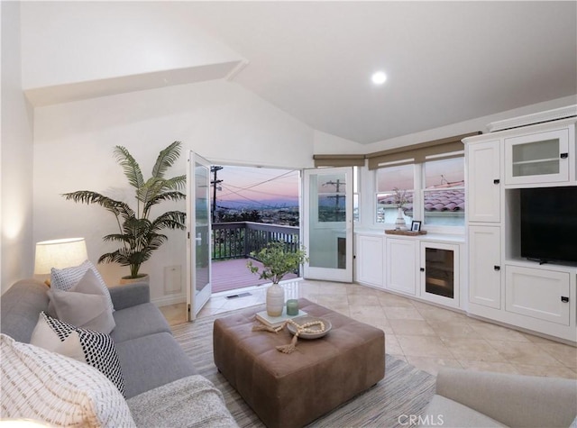 living room with vaulted ceiling, light tile patterned floors, and visible vents