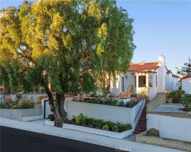 view of front of home featuring a garage, a tile roof, and stucco siding