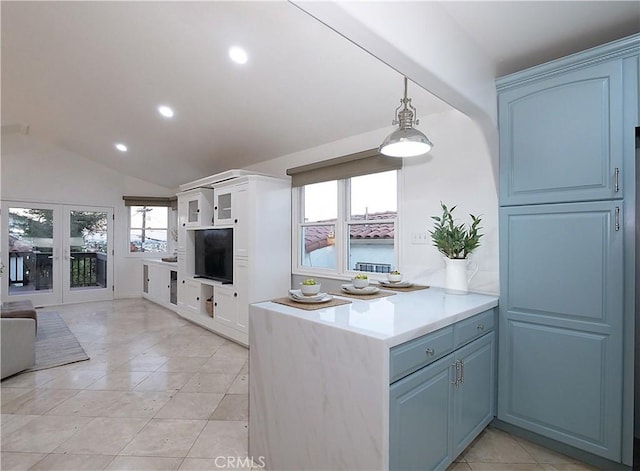 kitchen featuring recessed lighting, lofted ceiling, light countertops, hanging light fixtures, and open floor plan