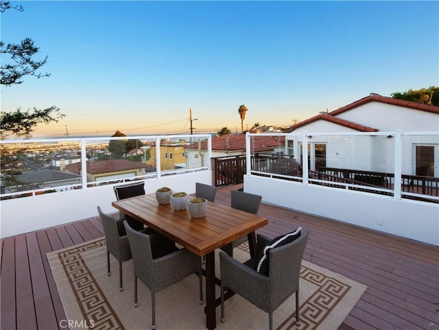 deck at dusk with outdoor dining area