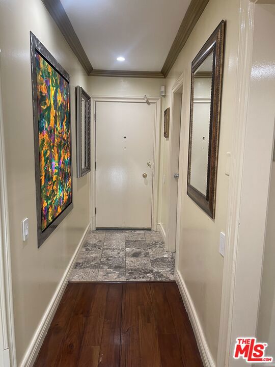 hall with hardwood / wood-style floors and ornamental molding