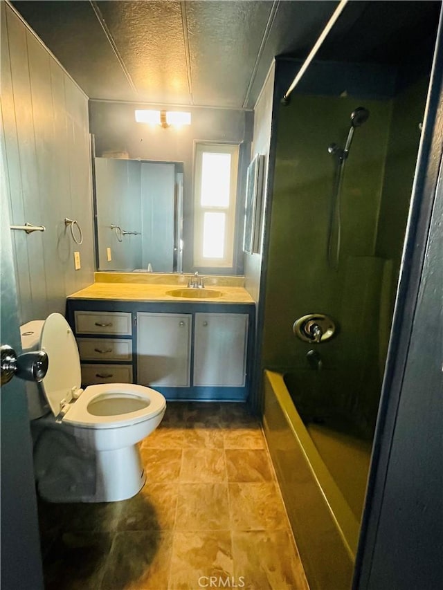 full bathroom featuring toilet, a textured ceiling, vanity, and bathing tub / shower combination