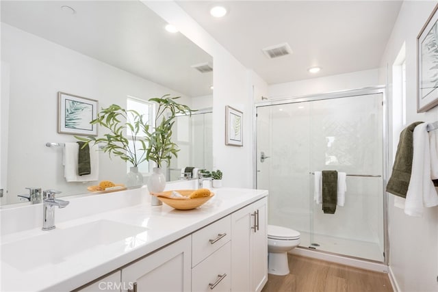 bathroom featuring hardwood / wood-style floors, vanity, toilet, and walk in shower