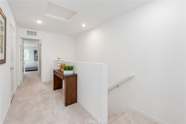 hall featuring light colored carpet