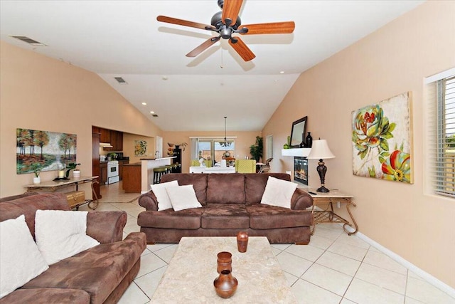 living room with light tile patterned floors, vaulted ceiling, and ceiling fan