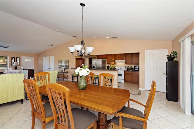 dining area featuring a chandelier, light tile patterned floors, and vaulted ceiling