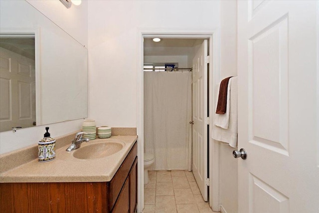 bathroom with tile patterned flooring, vanity, and toilet