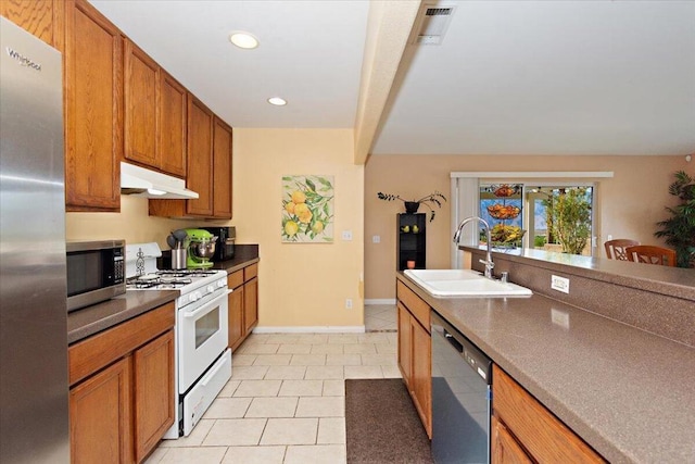 kitchen featuring sink, light tile patterned flooring, and appliances with stainless steel finishes