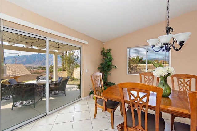 tiled dining space with a mountain view, vaulted ceiling, and a notable chandelier