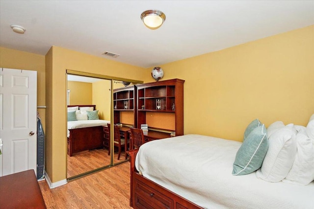 bedroom with light hardwood / wood-style flooring and a closet