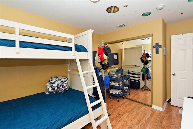 bedroom with hardwood / wood-style floors and a closet