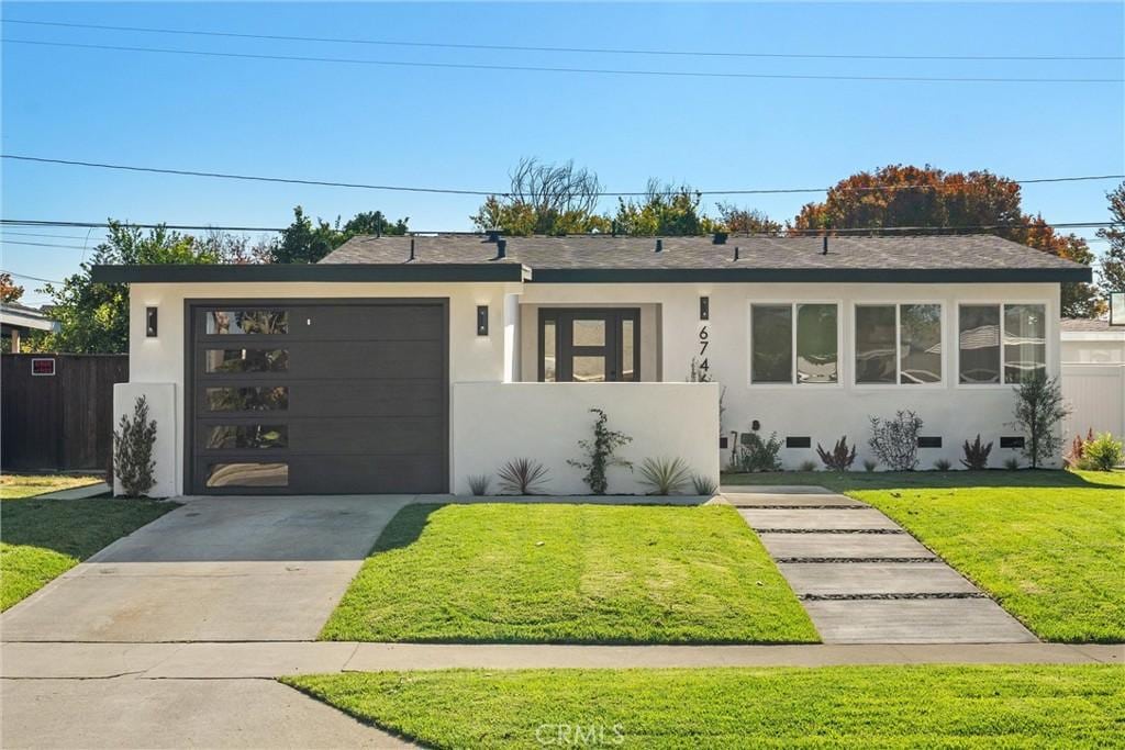 view of front of home featuring a front yard and a garage