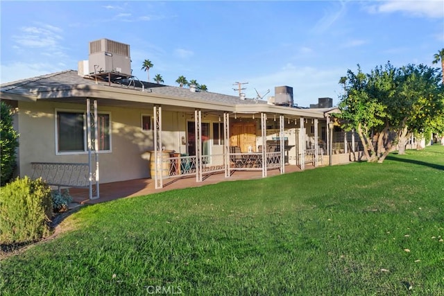 back of house featuring a lawn, central AC unit, and a patio