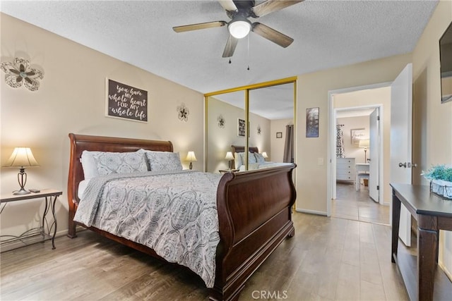 bedroom featuring wood-type flooring, a textured ceiling, a closet, and ceiling fan