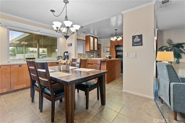 tiled dining room with a textured ceiling, a notable chandelier, and crown molding