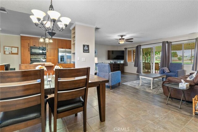 dining room with light wood-type flooring, a textured ceiling, and ceiling fan with notable chandelier