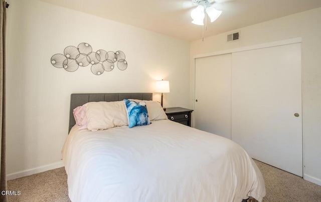 carpeted bedroom featuring a closet and ceiling fan