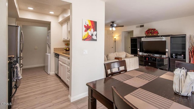 kitchen featuring light hardwood / wood-style flooring, white cabinetry, stainless steel appliances, and ceiling fan