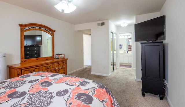 carpeted bedroom with ensuite bath and ceiling fan