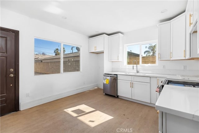 kitchen featuring white cabinets, dishwasher, light wood-type flooring, and sink